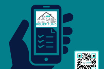 Hand holding a phone showing the AIM COVID Relief Fund application, with a QR code to apply